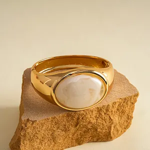 Detailansicht eines vintage Goldarmreifs mit einer eleganten weißen Marmorharz-Einlage