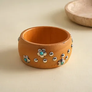 Detailansicht eines böhmischen Holzarmreifens mit Metallblumen und türkisfarbenen Perlen