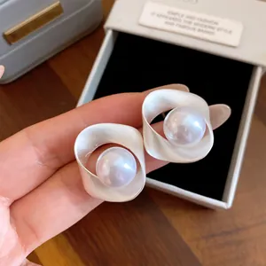 Elegante geometrische zilveren oorknopjes met parels getoond in een detailopname