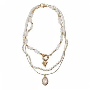 Collier de perles à trois rangs de style vintage français avec pendentifs dorés.