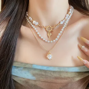 Détail d'un ensemble de colliers de perles vintage français avec un pendentif en cœur