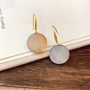 Elegante runde graue Perlmutt-Ohrhänger mit goldenen Haken, Schmuck-Detailansicht