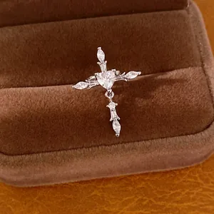 Clip d'oreille croix en forme de cœur argenté avec zircons brillants dans un écrin