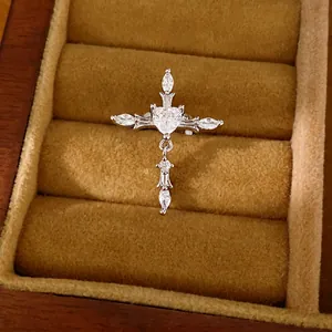 Clip d'oreille croix argenté élégant avec zircone en cœur dans un écrin à bijoux
