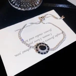 Gros plan d'un bracelet en argent rétro avec pierre ovale noire et zircons scintillants.