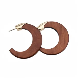 Moderne C-förmige Holz-Ohrringe mit elegantem Goldstecker auf weißem Hintergrund