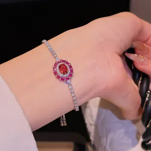Gros plan d'un bracelet vintage en zircon rouge avec des accents étincelants au poignet.