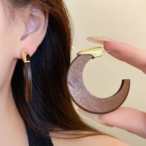 Detailansicht von runden Holzohrringen im Retro-Stil mit goldenem Akzent