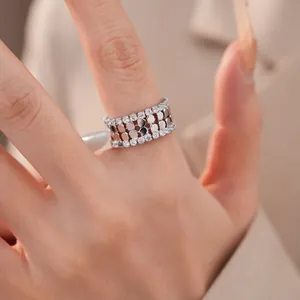 Detaillierte Makroansicht eines silberfarbenen, zweilagigen Zirkon-Rings am Finger