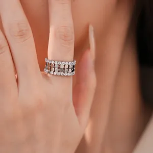 Nahaufnahme eines silberfarbenen doppelschichtigen Rings mit Zirkon und Wabenmuster-Detail.