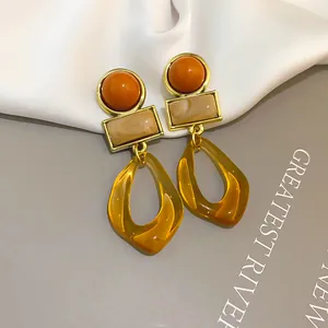 Detailed view of vintage geometric acrylic earrings featuring amber resin pendants