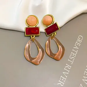 Close-up of vintage geometric acrylic dangle earrings in burgundy and tan colors
