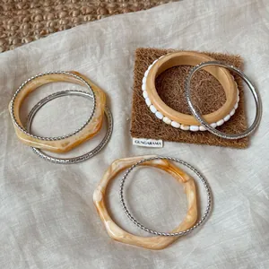 Detailansicht eines Armband-Sets aus Harz und Silber auf Leinenstoff