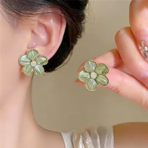 Vintage groene bloem oorbellen met gouden rand en kristal in het midden