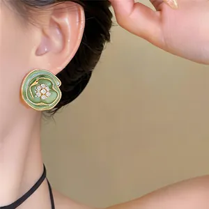 Gedetailleerd macro-overzicht van een vintage groene ronde oorbel met kristallen bloem