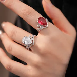 Gros plan de bagues avec zircons rouges et clairs taillés en poire et montures couronne.