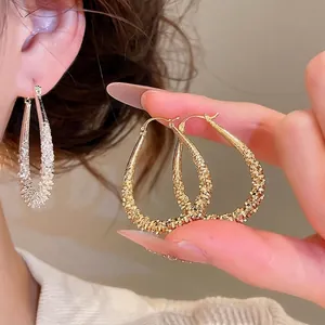 Elegant geometric waterdrop hoop earrings with textured gold finish for stylish women