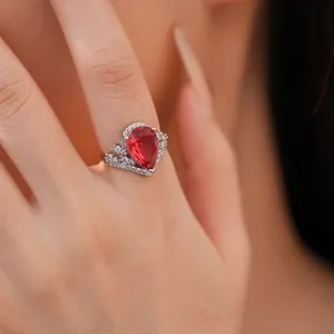 Vue rapprochée d'une bague à pierre rouge en forme de poire avec des accents de zircon