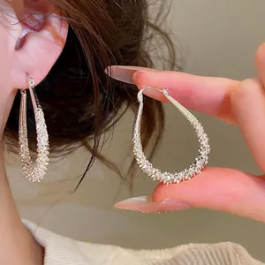 Elegant silver geometric teardrop hoop earrings featuring a unique sparkly textured finish