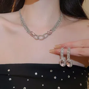 Detail of sparkling silver-tone necklace set with pink oval gemstones and rhinestones.