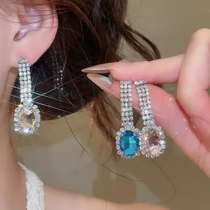Close-up of sparkling oval drop earrings with vibrant crystals and pavé rhinestones