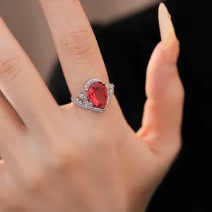 Vue détaillée d'une élégante bague vintage avec zircon rouge en forme de poire au doigt