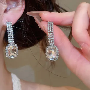 Macro detail of elegant silver-tone oval rhinestone dangle earrings with brilliant sparkle