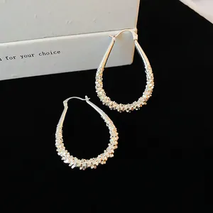 Detail view of silver-tone geometric waterdrop hoop earrings with textured surface