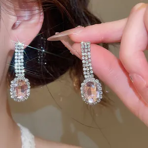 Close-up of elegant pink oval gemstone drop earrings with sparkly rhinestones