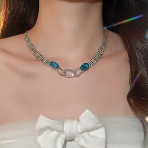 Close-up of sparkling silver-tone necklace with blue oval gems and rhinestone accents