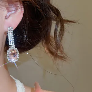 Detailed shot of elegant silver-tone earrings featuring a large pink oval crystal.