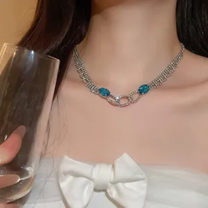Detailed close-up of elegant silver necklace with blue oval gems and sparkling crystals
