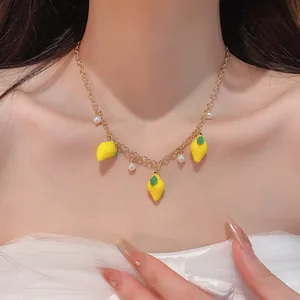 Detailed view of a sweet resin lemon and pearl pendant necklace on a model's neck