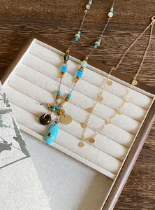 Détail du collier ethnique en perles avec pendentif turquoise et chaîne à disques dorés
