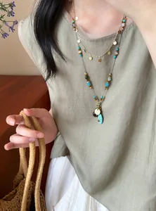 Détail d'un collier de perles bohème multicouche avec des pierres turquoise sur un modèle