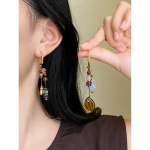 Détail de boucles d'oreilles ethniques vintage avec perles et pierres naturelles