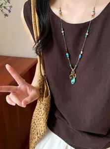 Vue détaillée d'un collier bohème avec pendentif turquoise ovale sur un mannequin