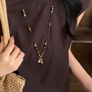 Vue détaillée d'un collier de perles ethnique rétro avec pierres colorées et pendentif