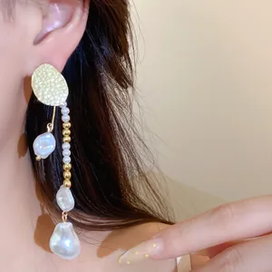 Detaillierte Makroansicht eleganter französischer Quastenohrringe mit Barockperlen.