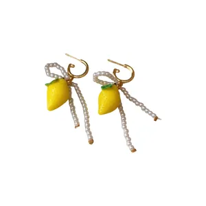 Fresh lemon drop earrings with dainty pearl bow and dangling strands for summer style.