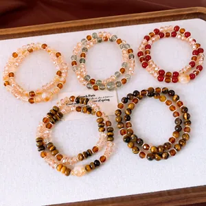 Vue détaillée de bracelets empilés en œil de tigre et perles de cristal de diverses couleurs