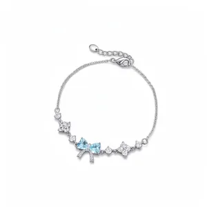 Elegant silver bow bracelet with light blue heart zircons and flower charms.