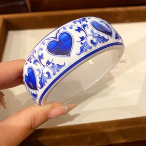 Close-up detail of blue and white porcelain style resin bangle with blue heart patterns