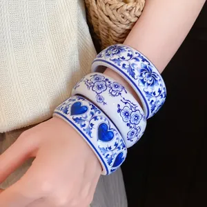 Detail view of blue and white porcelain style resin bangles with floral and heart patterns