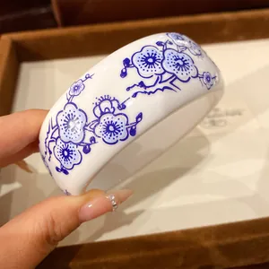 Close-up detail of a blue and white porcelain style resin bracelet with elegant floral patterns
