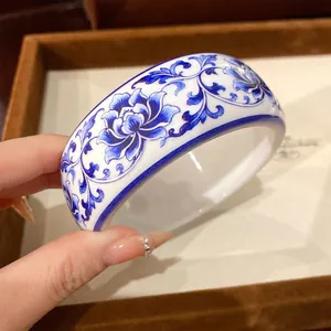 Detail of Chinoiserie blue and white floral pattern on resin wide bangle bracelet