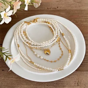 Elegante mehrlagige Perlenkette mit goldenem Herzanhänger im französischen Vintage-Stil.