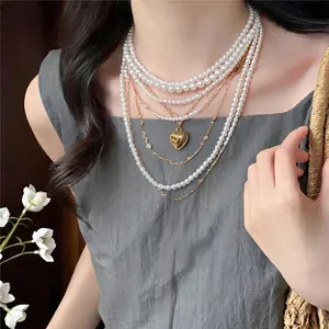 Elegante mehrlagige Perlenkette mit goldenem Herzanhänger im französischen Vintage-Stil