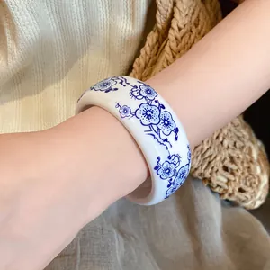 Close-up of blue and white porcelain style resin bangle with exquisite floral pattern.