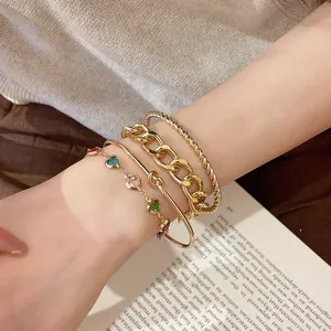 Detailaufnahme eines 4-teiligen goldenen Armband-Sets mit bunten Herzperlen am Handgelenk